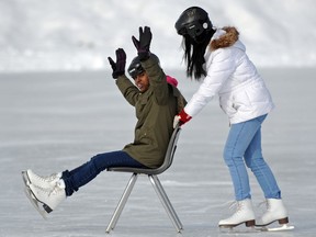 Shukria Tahir from Eritrea gets a push from Liying Xiu from China, both 16, when ESL students from Queen Elizabeth High school enjoyed a skating outing in Hawrelak Park in Edmonton on Friday, Mar. 7, 2014. (photo by John Lucas/Edmonton Journal)(standalone)