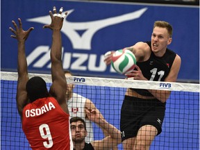 Canada's Daniel Cornelius Jansen Vandoorn spikes the ball on Cuba's Livan Osoria Rodriguez during the final match of the NORCECA Continental Olympic qualification men's volleyball tournament at Saville Community Sportrs Centre on Jan. 10, 2016.