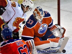 Edmonton Oilers goalie Cam Talbot (33) makes the save as Calgary Flames Micheal Ferland (79) is on the door step during NHL action at Rexall Place in Edmonton, Jan. 16, 2016.