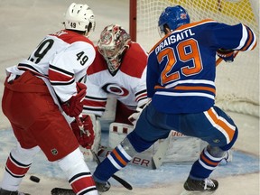 Goalie Cam Ward (30) makes a save with Leon Draisaitl (29 and Victor Rask (49) in front as the Carolina Hurricanes play the Edmonton Oiler in Edmonton on Monday.