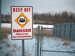A warning sign beside Poplar Lake, a storm-water pond in Edmonton's Klarvatten neighbourhood.