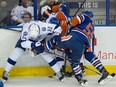 Players fight along the boards as the Edmonton Oilers take on the Tampa Bay Lightning in Edmonton, Jan. 8, 2016.