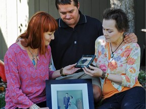 From left: Linda-Rae Carson, Todd Walker and Kathie Peterson with a portrait of their parents, Sheila and Allen Walker, who were killed in crash on Highway 16 on June 29, 2013.