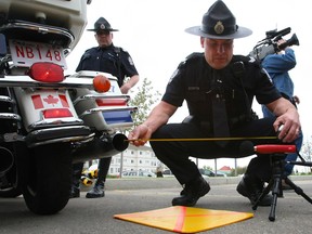 Traffic section Sgt. Eric Theuser demonstrates the use of a sound level meter to determine motorcycle noise.