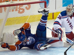 Edmonton Oilers defenceman Oscar Klefbom gets tripped and ends up in the net behind New York Rangers goaltender Henrik Lundqvist during an NHL game at Rexall Place on Dec. 11, 2015.