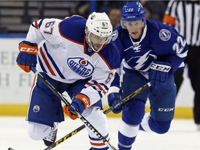 Benoit Pouliot (67) of the Edmonton Oilers avoids a check from Erik Condra (22) of the Tampa Bay Lightning at the Amalie Arena on Jan. 19, 2016, in Tampa, Fla.