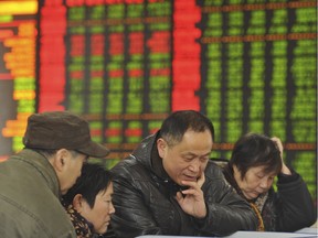 FILE - In this Friday, Nov. 27, 2015, file photo, Chinese investors monitor stock prices at a brokerage house in Fuyang in central China's Anhui province. China's sharp economic slowdown and its surprise decision to devalue its currency squeeze emerging economies, roil financial markets and escalate fears about the global economy was one of The Associated Press' top stories in 2015. (Chinatopix via AP) CHINA OUT