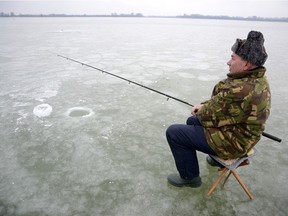 Ice fisherman Andras Merten waits for a catch during subzero temperatures on the frozen Lake Tisza near Abadszalok, 159 kilometers east of Budapest, Hungary, Monday, Jan. 4, 2016.