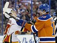 Calgary Flames' Johnny Gaudreau (13), left, is cross-checked by Edmonton Oilers' Nail Yakupov (10) during first period NHL action in Edmonton, Alta., on Saturday, Oct. 31, 2015.