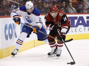 Arizona Coyotes' Max Domi (16) tries to keep the puck away from Edmonton Oilers' Lauri Korpikoski (28), of Finland, during the first period of an NHL hockey game Tuesday, Jan. 12, 2016, in Glendale, Ariz.