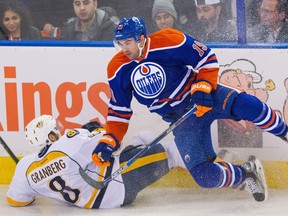 Defencemen Petter Granberg of the Nashville Predators and Justin Schultz of the Edmonton Oilers collide during NHL action in Edmonton on Jan. 23, 2016.