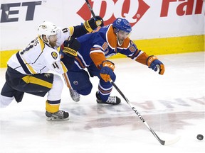 Nashville Predators defenceman Ryan Ellis, left, battles Edmonton Oilers forward Benoit Pouliot during NHL action at Rexall Place, in Edmonton on Jan. 23, 2016.