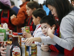 A family helps sort food at a Toronto-area food bank before Christmas.  Money donations help food banks buy perishables.