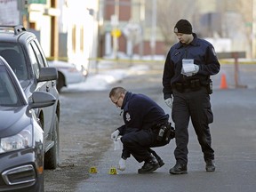 Police investigate the scene of a shooting on 111th Avenue near 93rd Street in Edmonton on Jan. 1, 2016.