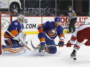 New York Islanders defenceman Travis Hamonic helps goalie Thomas Greiss defend against the Carolina Hurricanes in an NHL game in New York on Oct. 29, 2015.