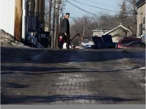 A pedestrian walks through an alley north of 106th Avenue near 123rd Street, in Edmonton on Wednesday, Feb. 3, 2016.