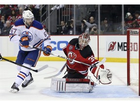New Jersey Devils goalie Cory Schneider makes a glove save on a shot by Edmonton Oilers left wing Benoit Pouliot during the first period of Tuesday's game in Newark, N.J.