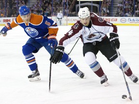 Colorado Avalanche's Blake Comeau is pressured by Edmonton Oilers' Mark Fayne during first period NHL action, in Edmonton, on Feb. 20, 2016.