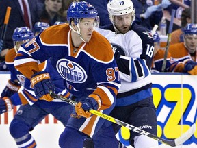 Winnipeg Jets' Bryan Little (18) and Edmonton Oilers' Connor McDavid (97) battle for the puck during first period NHL action in Edmonton on February 13, 2016.