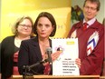 Danielle Larivee, minister of municipal affairs and co -chair of the Alberta Mental Health Review, holds the report along with provincial Minister of Health Sarah Hoffman, and co-chair Dr David Swann during a press briefing on Feb. 22, 2016 at Hull Family Services.