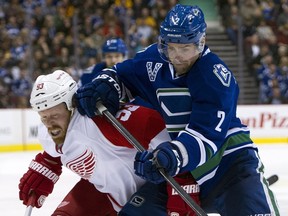 Dan Hamhuis #2 of the Vancouver Canucks gets tangled up with Johan Franzen #93 of the Detroit Red Wings while battling for position during the third period in NHL action on April 20, 2013 at Rogers Arena in Vancouver.