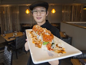 Washoku Bistro owner/chef Ken Lee holds a plate of Crispy Crunch Roll.