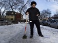 Colin Stewart, municipal enforcement officer for the City of Edmonton, inspects an icy sidewalk. Coun. Michael Walters wants to bring back boxes of sand so residents can make slippery sidewalks safer.