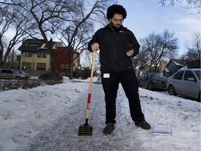 Colin Stewart, municipal enforcement officer for the City of Edmonton, inspects an icy sidewalk. Coun. Michael Walters wants to bring back boxes of sand so residents can make slippery sidewalks safer.