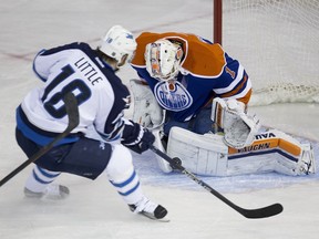 Edmonton Oilers Laurent Brossoit makes a save on Winnipeg Jets Bryan Little during first period NHL action on February 13,  2016 in Edmonton.