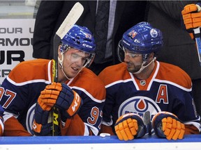 Connor McDavid, left, and Jordan Eberle talk on the bench during Tuesday's NHL action at Rexall Place.