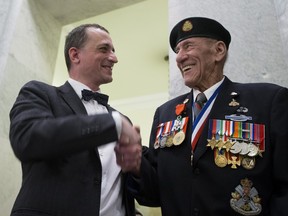 French Consul General Jean-Christophe Fleury shakes the hand of Douglas Maurice White, thanking him for his role in the D-Day invasion after presenting him the Medal of the Legion of Honour during a ceremony Monday at Alberta's legislature.