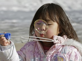 Four-year-old Kokoha Terada makes some bubbles at the Family Day festivities held around City Hall on Monday, Feb. 15, 2016.