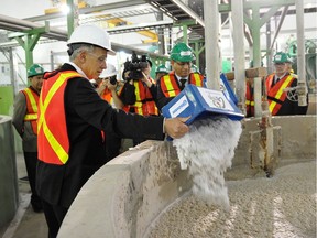 Edmonton Mayor Stephen Mandel dumps some shredded cotton in a vat of pulp at the Greys Paper Recycling Industries Ltd. facility in Edmonton on May 16, 2013.