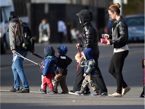 Daycare workers walk toddlers on leads downtown in Edmonton on Oct. 6, 2015.