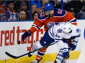 Eric Gryba and Leafs forward Mark Arcobello fight for the puck during second-period action at Rexall Place Thursday.