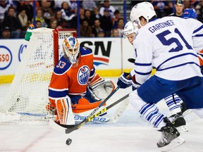Goalie Cam Talbot (33) of the Edmonton Oilers keeps his eyes on the puck as Jake Gardiner (51) of the Toronto Maple Leafs charges at Rexall Place in Edmonton, Alta. on Feb. 11, 2016.