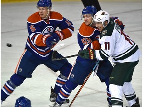 Edmonton Oilers Mark Letestu (55) ties up Minnesota Wild Zach Parise (11) as the puck flies past Mark Fayne (5) during NHL action at Rexall Place Thursday.