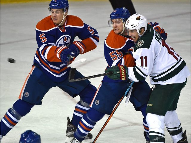 Edmonton Oilers Mark Letestu (55) ties up Minnesota Wild Zach Parise (11) as the puck flies past Mark Fayne (5) during NHL action at Rexall Place in Edmonton, February 18, 2016.