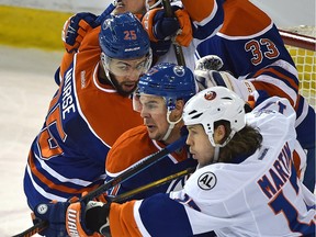 Battles in front of Edmonton Oilers net Adam Clendening (27) and Darnell Nurse (25) and New York Islanders Matt Martin (17) and Anders Lee (27) during NHL action at Rexall Place in Edmonton, February 28, 2016. (ED KAISER/PHOTOGRAPHER)