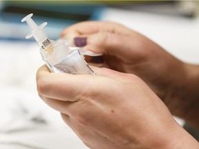 A registered nurse prepares a flu shot  at Woodcroft Public Health Centre in Edmonton last November.