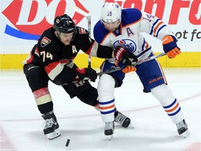 Edmonton Oilers' Jordan Eberle fights to keep the puck from Ottawa Senators' Mark Borowiecki during second-period NHL hockey action in Ottawa on Thursday, Feb. 4, 2016. Eberle had two goals and an assist as the Oilers won 7-2.