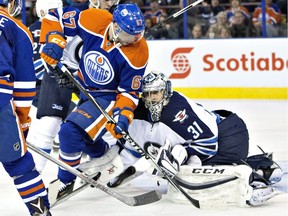Winnipeg Jets goalie Ondrej Pavelec is screened by Edmonton Oilers forward Benoit Pouliot during second period NHL action in Edmonton on February 13, 2016.