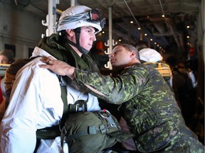 Paratroopers with the 3rd Canadian Division Princess Patricia Canadian Light Infantry (3 PPCLI) are inspected by jumpmasters as they prepare to jump out of a CC-150J Hercules aircraft near Resolute Bay on Feb. 12, 2016
