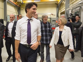 Prime Minister Justin Trudeau, centre, and Alberta Premier Rachel Notley, right, tour the International Brotherhood of Electrical Workers training facility in Edmonton on  Feb. 3.