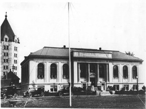 The original Edmonton Public Library, shown in this photo from 1924, was built at 100 Avenue and 100t Street. One of the distinctive turrets of the Hotel Macdonald is visible on the left side of the photo.