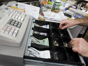 A store proprietor takes change from his cash register in a 2009 file photo.