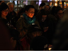 Robin Eaglewhistleblower holds a candle surrounded by supporters at a vigil for missing and murdered indigenous women at Churchill Square in Edmonton on Wednesday, Feb. 10, 2016.