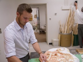 Greg Funston, a researcher at the University of Alberta, measures a fossil mould in the biological sciences building in 2014.