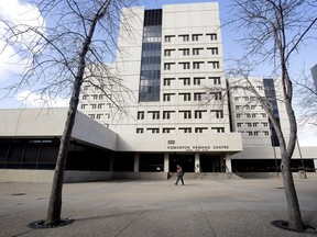 A pedestrian walks past the front entrance to the former Edmonton Remand Centre, which a developer says should be turned into affordable housing.