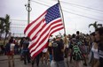 Fans from the US carrying a flag arrive to the venue where the Rolling Stones will play their concert in Havana, Cuba, Friday, March 25, 2016. The Stones are performing in a free concert in Havana Friday, becoming the most famous act to play Cuba since its 1959 revolution.(AP Photo/Ramon Espinosa)